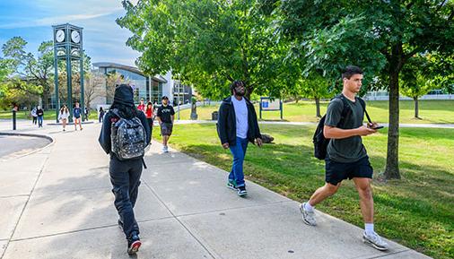 Students walking outside on campus in front of Clock Tower